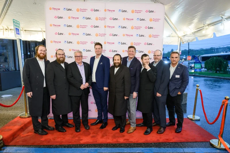 A group photo at the Thryve and Lev Health Center backdrop.