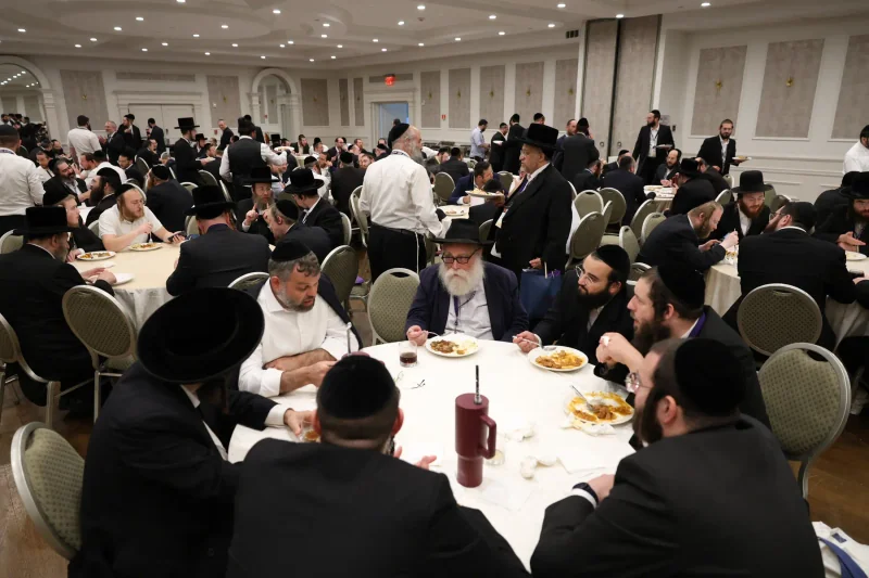 Participants gathered around tables inside the Neshumah conference hall