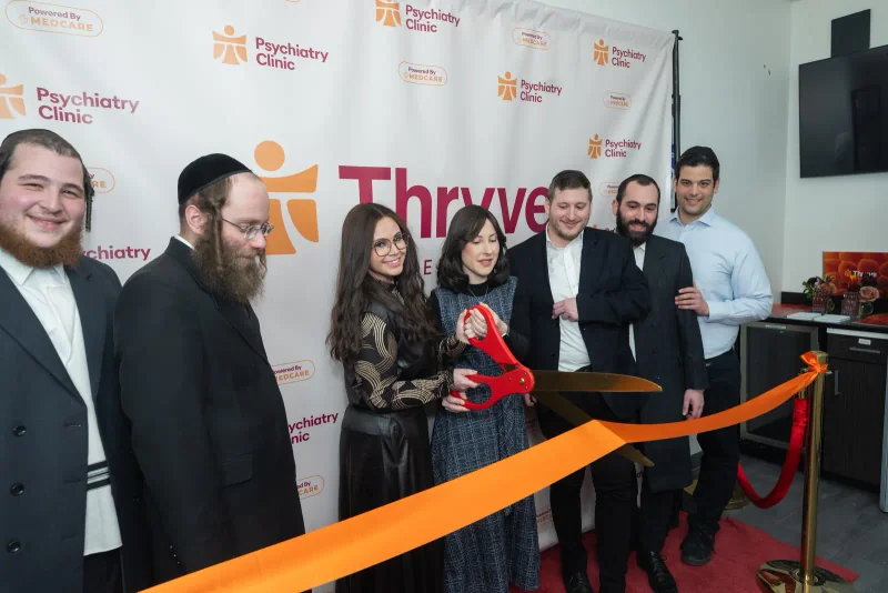 The orange ribbon being cut at the Williamsburg grand opening