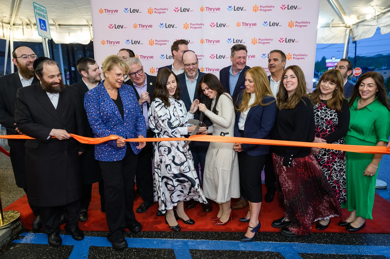 The orange ribbon is cut at the Monsey program opening.